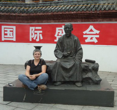 Sylvie Robert auprès d'une statue, en Chine